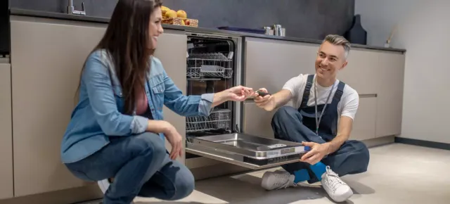 Best Pro technician explaining a repair to a customer in her kitchen